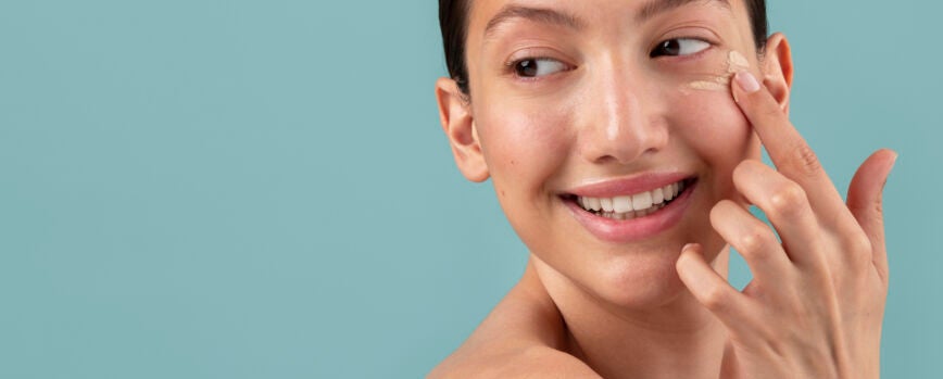 Vista lateral mujer aplicando crema facial