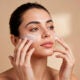 Mujer que aplica la crema en la cara