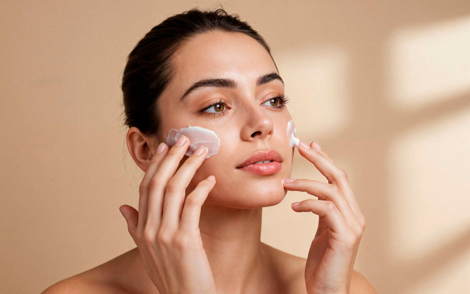 Mujer que aplica la crema en la cara
