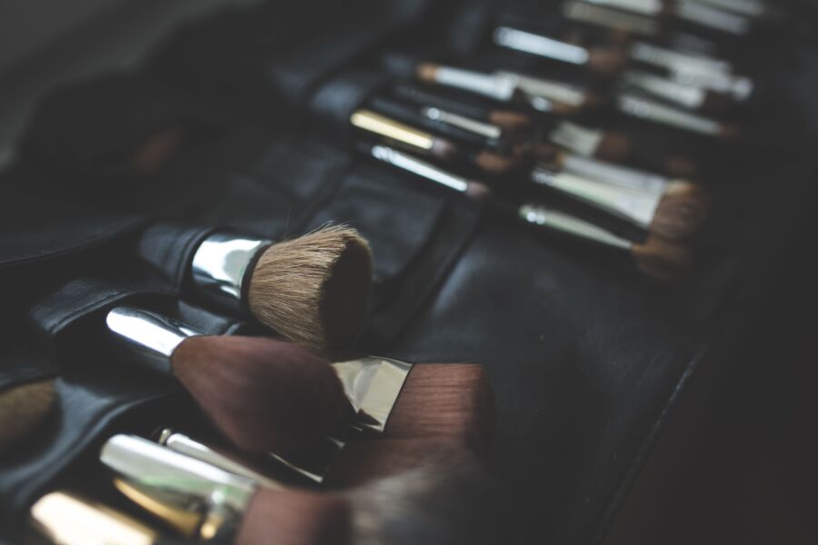 Un elegante arreglo de pinceles de maquillaje sobre un fondo oscuro y elegante.