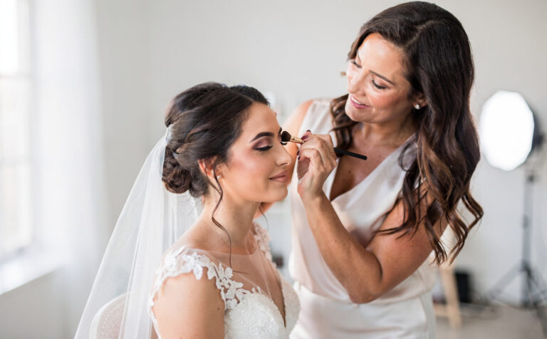 maquillando a una mujer vestida de novia
