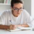 persona concentrada entudiano o tomando notas con gafas