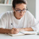 persona concentrada entudiano o tomando notas con gafas