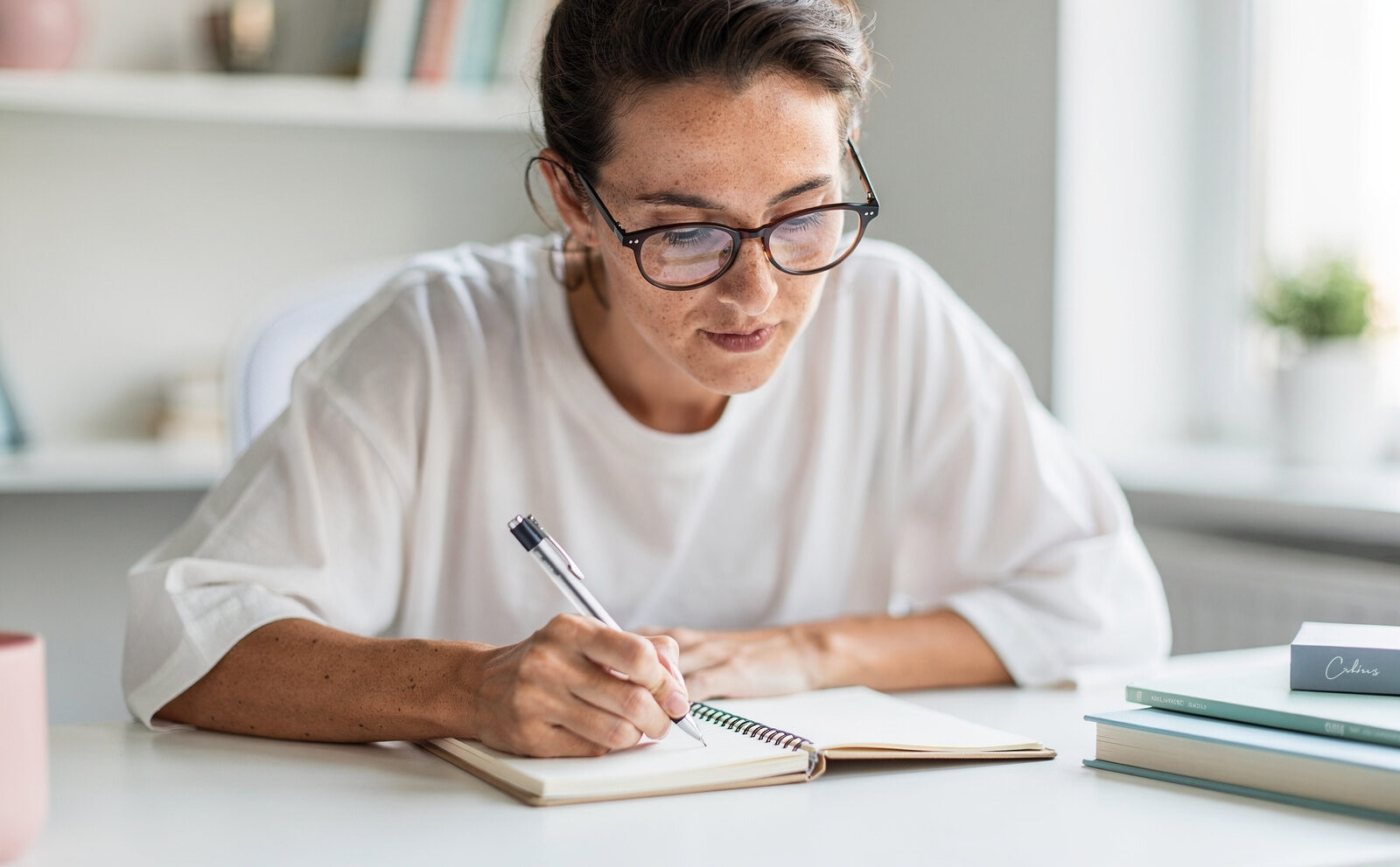 persona concentrada entudiano o tomando notas con gafas