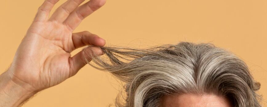 Anciano sosteniendo su cabello gris