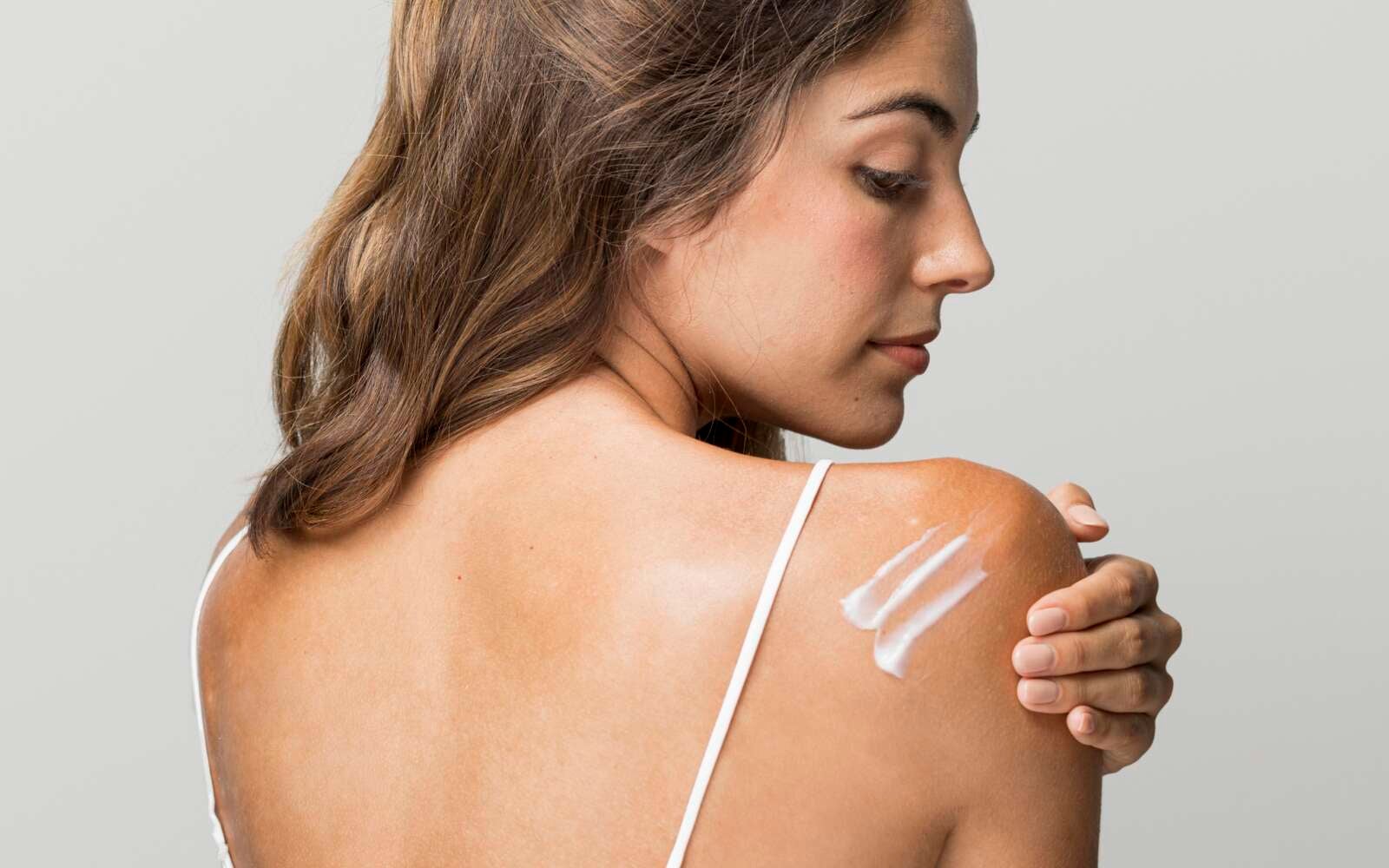 Mujer hermosa con crema en la espalda