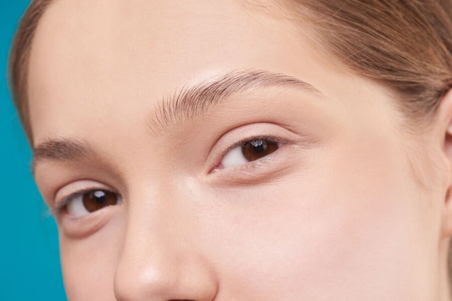 Una foto de primer plano que muestra el detalle natural de la piel y los ojos de una mujer, enfatizando la belleza natural.