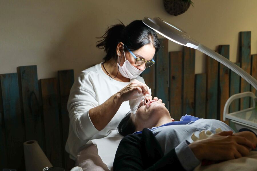 Esteticista proporciona un tratamiento facial detallado a un cliente en un entorno de spa.