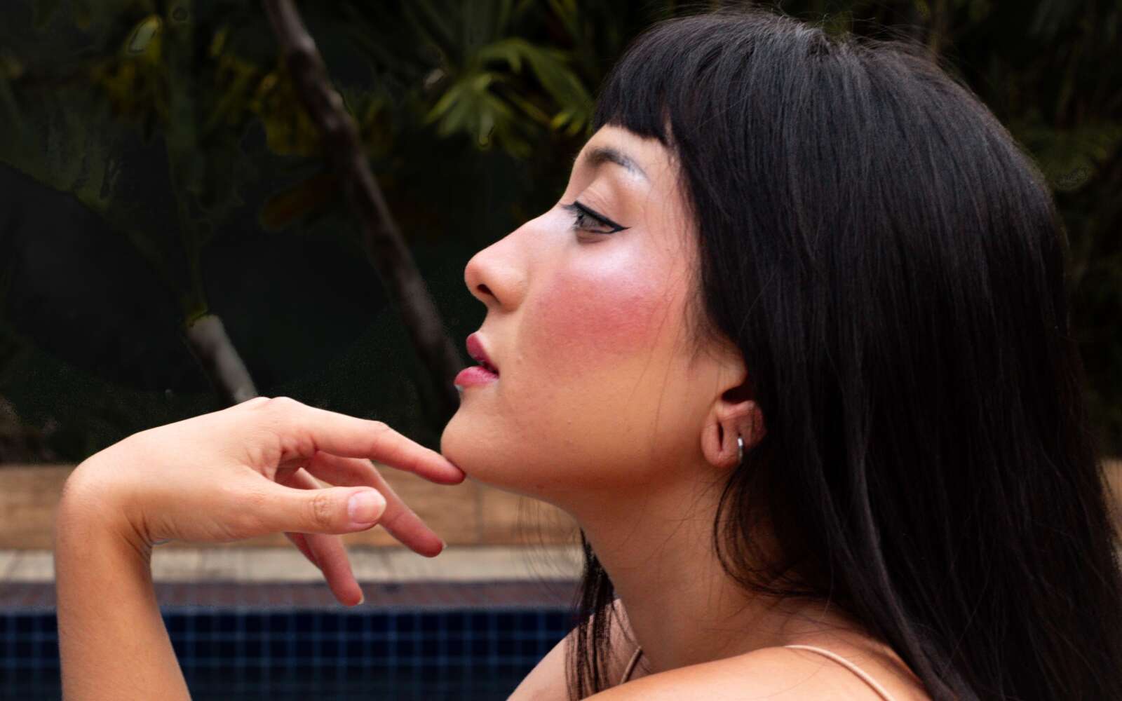 Retrato artístico de mujer junto a la piscina en São Paulo, destacando la elegancia y la belleza.