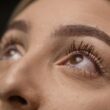 Primer plano detallado de los ojos femeninos mirando hacia arriba con pestañas largas y enfoque suave.