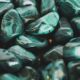 Primer plano de piedras de malaquita pulidas que muestran intrincados patrones y vibrantes tonos verdes.