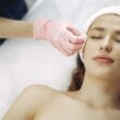 Mujer disfrutando de un relajante tratamiento facial en un entorno de spa sereno, promoviendo la relajación y la belleza.