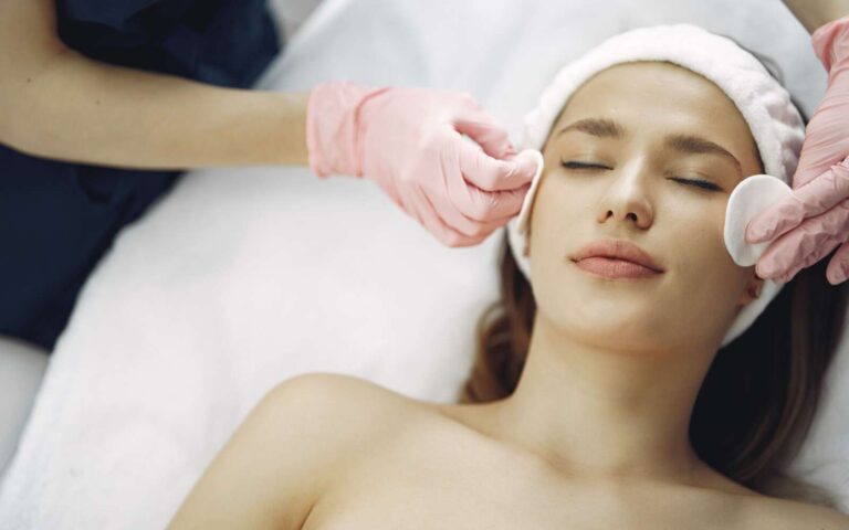 Mujer disfrutando de un relajante tratamiento facial en un entorno de spa sereno, promoviendo la relajación y la belleza.