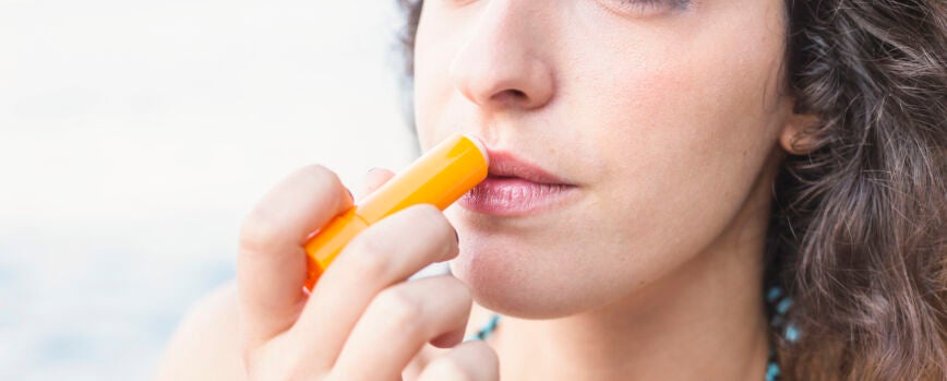 Primer plano de mujer joven aplicar bálsamo labial