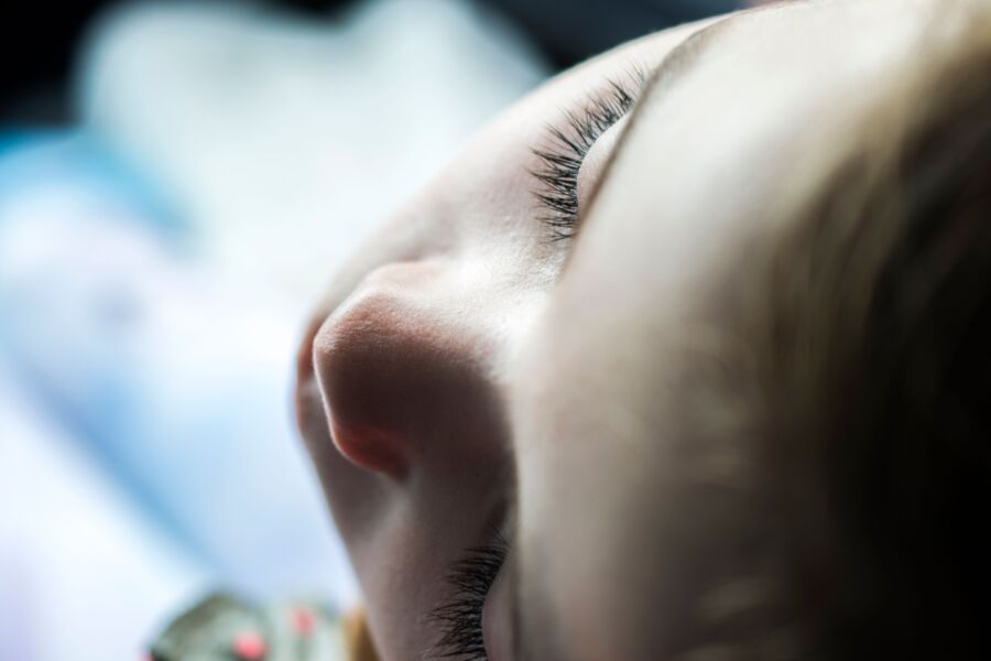 Foto íntima en primer plano de la cara de un niño con luz suave, centrándose en las pestañas serenas.