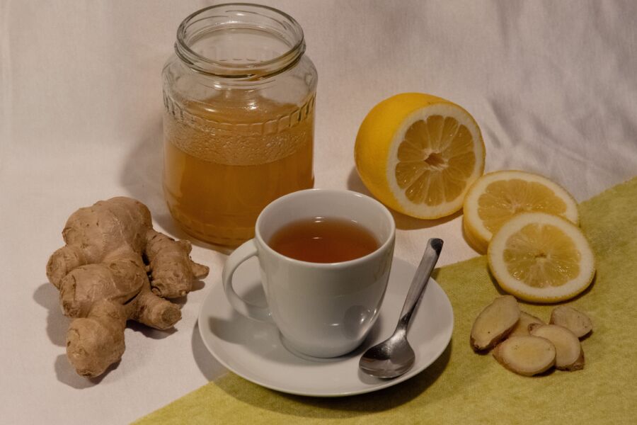 Una configuración acogedora con té de jengibre y limón con miel, que promueve el bienestar y la comodidad.