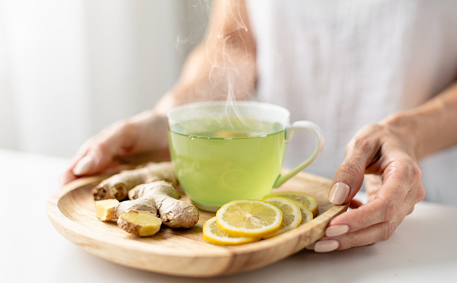 genra una i,agen  con una taza de te verde y jengibre y limon