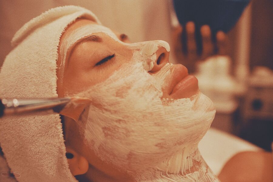 Un tratamiento facial relajante de spa con una mujer que recibe una lujosa aplicación de mascarilla facial.