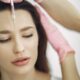 Primer plano del tratamiento facial con inyección en un entorno de spa, centrándose en la frente.