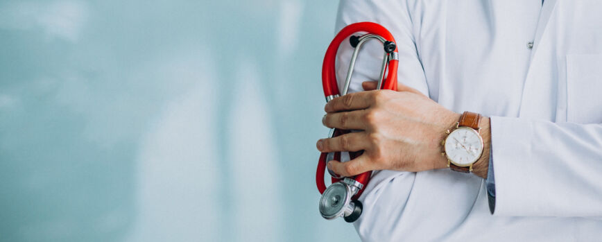 Joven y apuesto médico con bata médica y estetoscopio