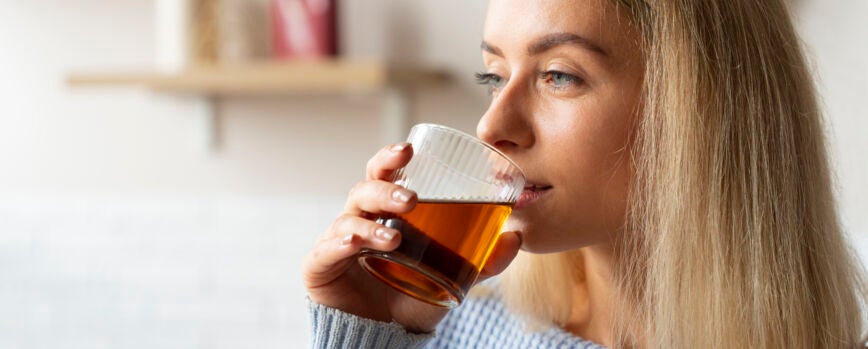 Vista lateral mujer bebiendo kombucha